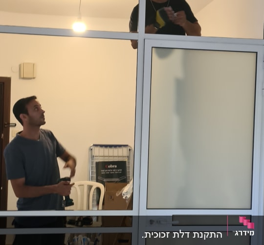 עובדים מתקינים מסגרת אלומיניום עם זכוכית חלבית
